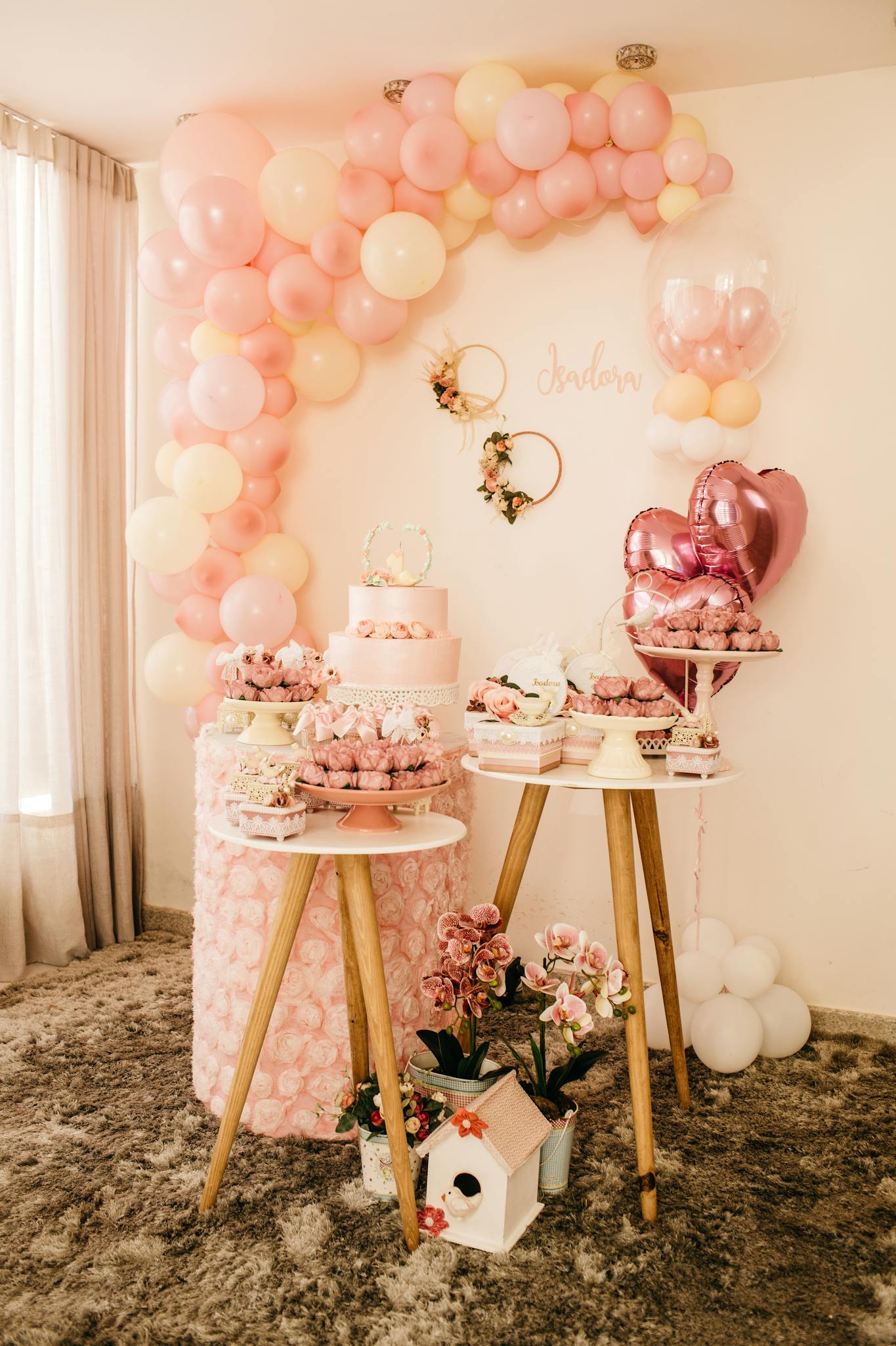 Beautiful pink themed dessert table with cake and balloons for a wedding celebration.